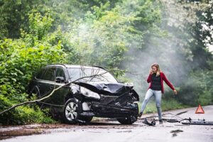 A woman calling the police after a car crash.