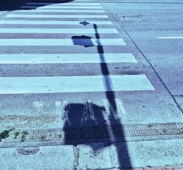 Pedestrian lines and a shadow of a light or traffic pole.