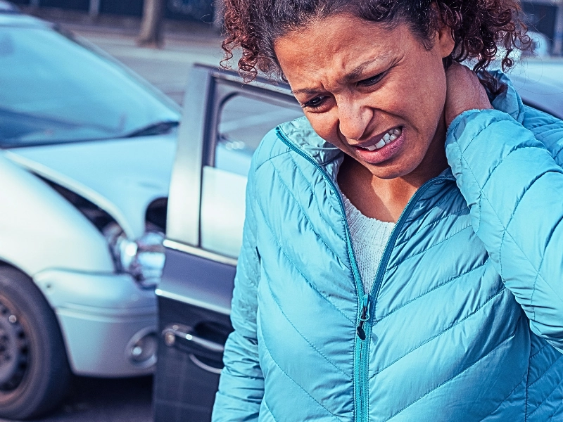 Woman with a painful neck ache after fender bender car crash. Rear-End Collisions in Stop-and-Go Traffic
