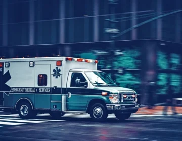A United States emergency ambulance driving on a city street at night.