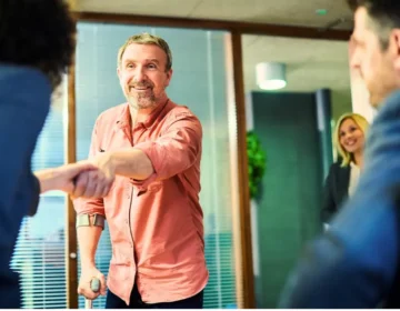 A happy and relieved man shaking hands with his lawyer in a law office What Does a Personal Injury Lawyer Do