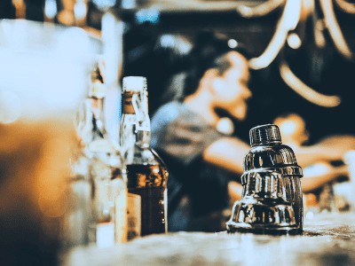 Some bottles of liquor on a bar counter and a bartender in the background. injury at a Cincinnati bar